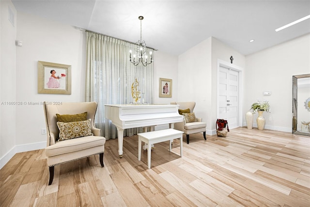 living area featuring an inviting chandelier and light hardwood / wood-style floors