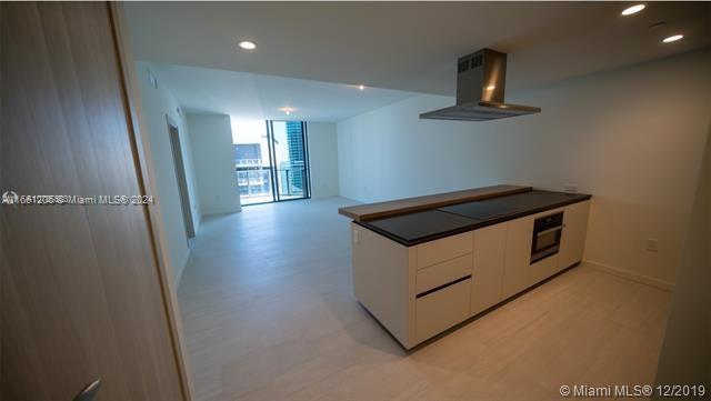 kitchen with white cabinets, oven, and exhaust hood