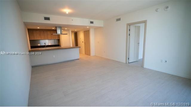 kitchen with kitchen peninsula, extractor fan, and a breakfast bar