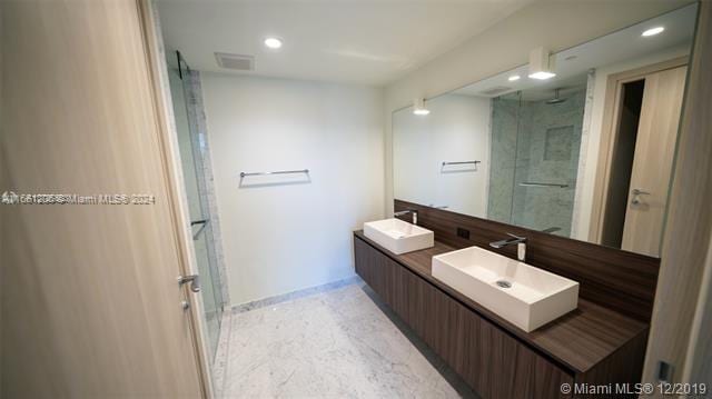 bathroom featuring vanity and a shower with shower door