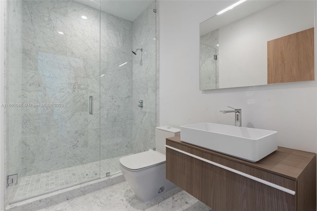 bathroom featuring vanity, a shower with shower door, and toilet