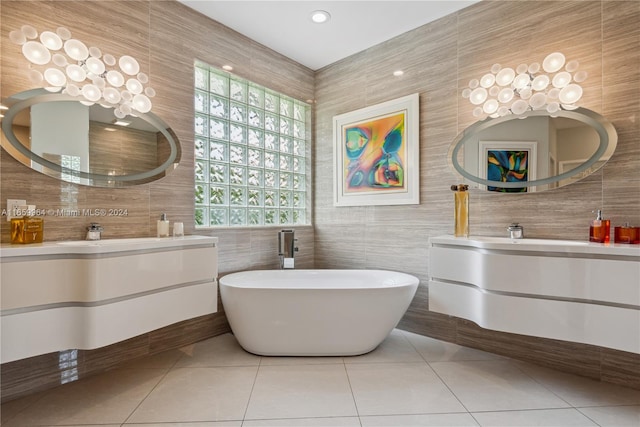 bathroom with tile walls, tile patterned flooring, vanity, and a washtub