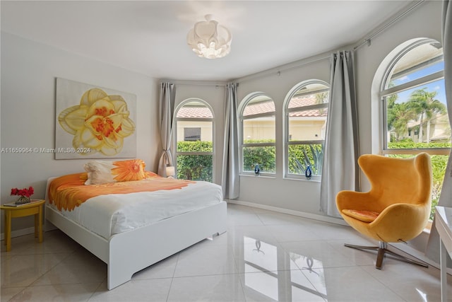 tiled bedroom featuring a chandelier and multiple windows