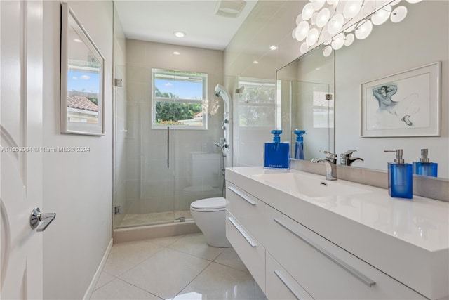 bathroom featuring tile patterned flooring, a shower with door, vanity, and toilet