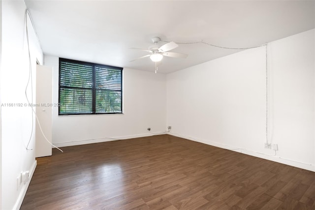 empty room with dark hardwood / wood-style floors and ceiling fan