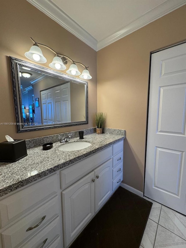 bathroom with tile patterned flooring, baseboards, crown molding, and vanity