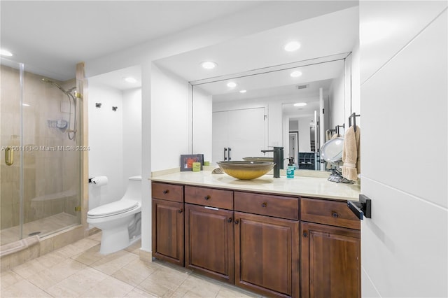 bathroom with tile patterned floors, vanity, toilet, and a shower with shower door