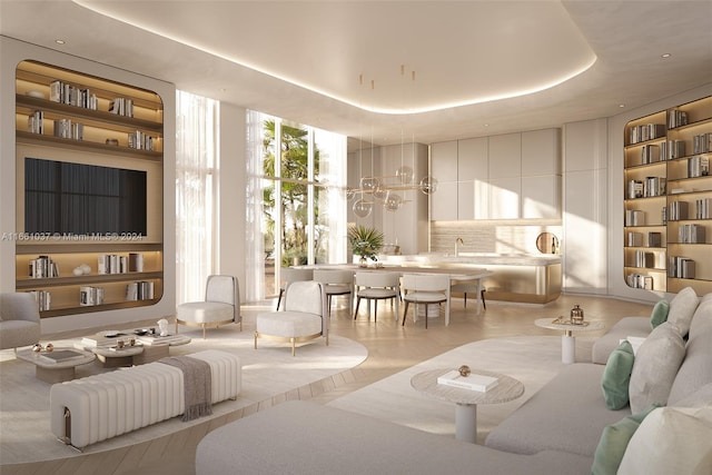 living room featuring a tray ceiling and sink