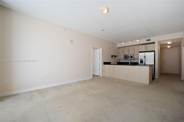 unfurnished living room with rail lighting and light carpet