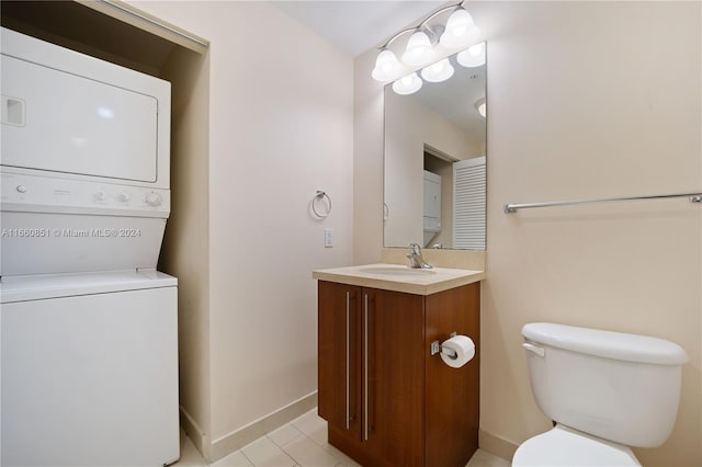 bathroom featuring vanity, tile patterned flooring, toilet, and stacked washing maching and dryer