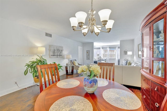 dining room with dark hardwood / wood-style floors and a chandelier