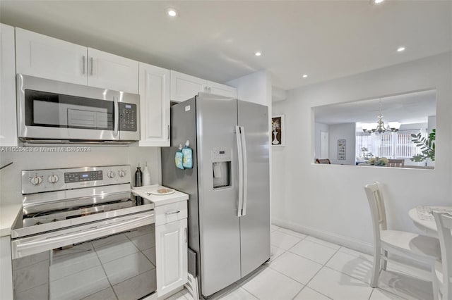 kitchen with white cabinetry, an inviting chandelier, light tile patterned floors, and stainless steel appliances