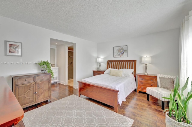 bedroom with a textured ceiling and hardwood / wood-style floors