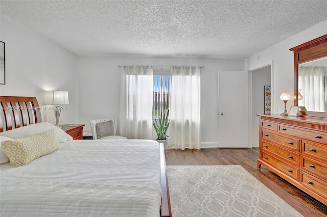 bedroom with light hardwood / wood-style floors and a textured ceiling