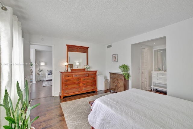 bedroom with a closet, light hardwood / wood-style floors, and a textured ceiling