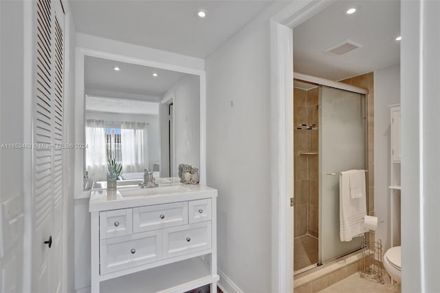 bathroom with walk in shower, vanity, tile patterned flooring, and toilet