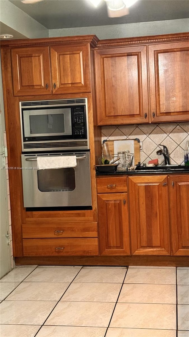 3800 S Ocean Dr Unit 416, Hollywood, FL 33019 - kitchen featuring dark countertops, tasteful backsplash, brown cabinetry, and appliances with stainless steel finishes