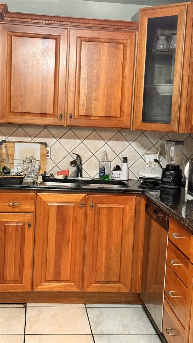 3800 S Ocean Dr Unit 416, Hollywood, FL 33019 - kitchen featuring stainless steel dishwasher, brown cabinetry, dark stone countertops, a sink, and decorative backsplash