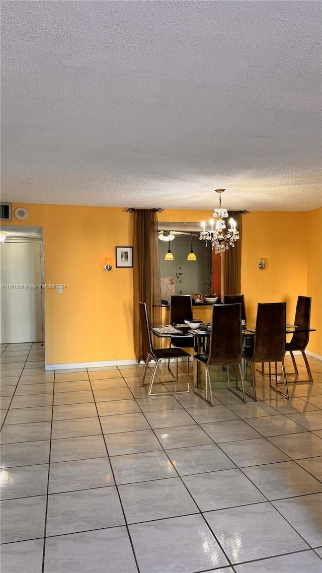 tiled dining room featuring a textured ceiling and a notable chandelier