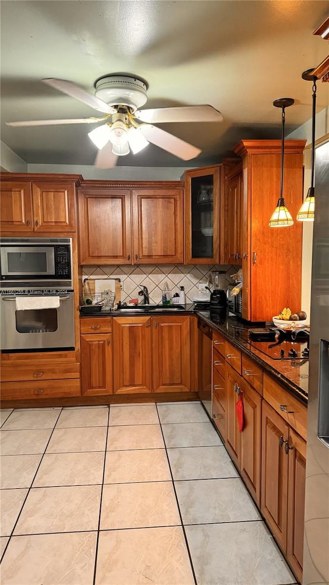 kitchen with ceiling fan, light tile patterned flooring, decorative light fixtures, appliances with stainless steel finishes, and decorative backsplash