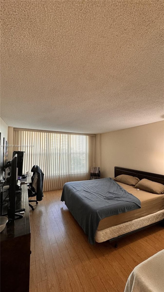 bedroom featuring a textured ceiling and wood-type flooring