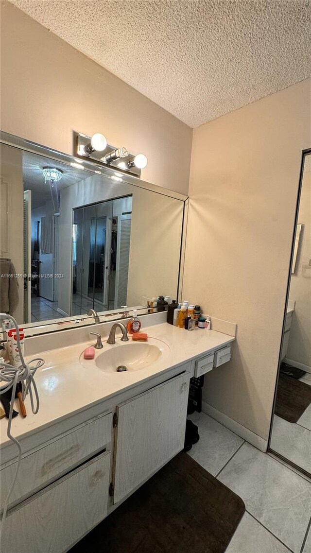 bathroom featuring a textured ceiling, vanity, and tile patterned floors