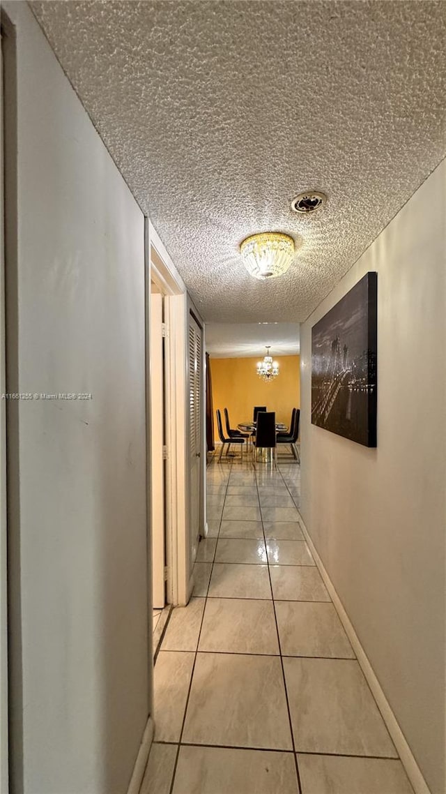 hall featuring a textured ceiling and tile patterned floors