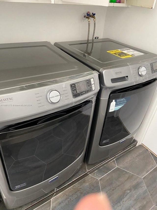 laundry area featuring separate washer and dryer and dark tile patterned floors