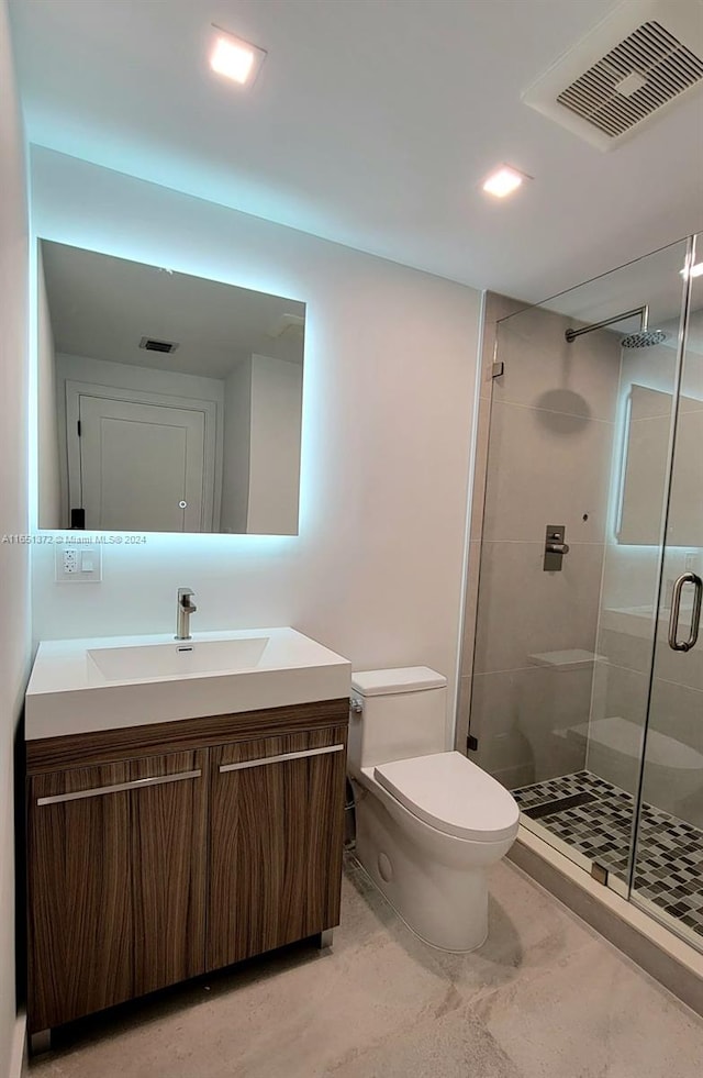 bathroom featuring vanity, toilet, and an enclosed shower