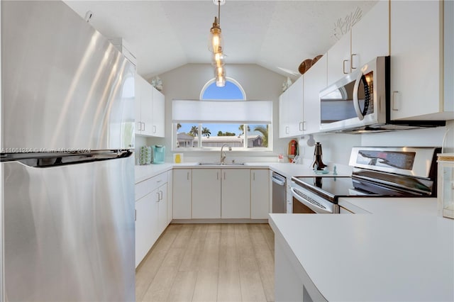 kitchen featuring hanging light fixtures, white cabinetry, sink, and stainless steel appliances