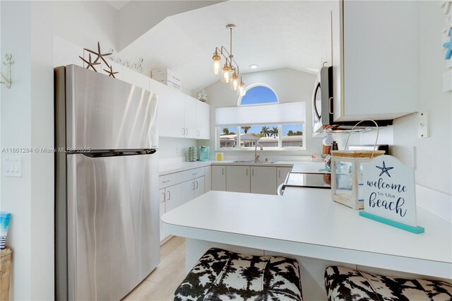 kitchen with appliances with stainless steel finishes, light hardwood / wood-style floors, white cabinetry, and sink