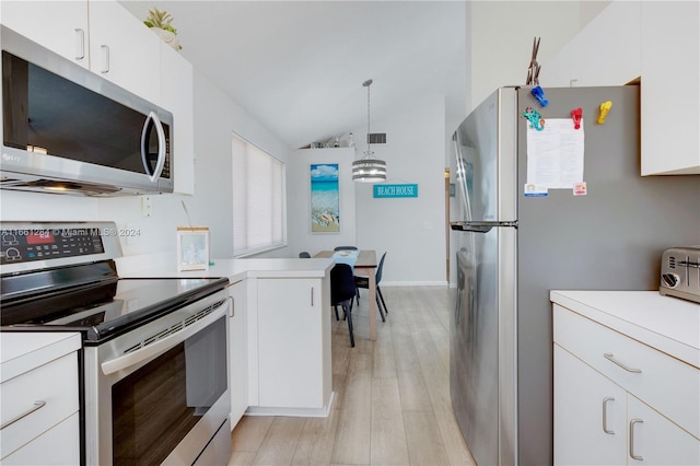 kitchen with vaulted ceiling, white cabinets, pendant lighting, stainless steel appliances, and light wood-type flooring