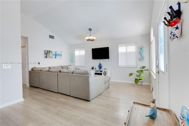 living room with light hardwood / wood-style floors and vaulted ceiling