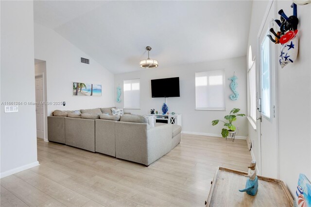 living room with light hardwood / wood-style flooring and lofted ceiling