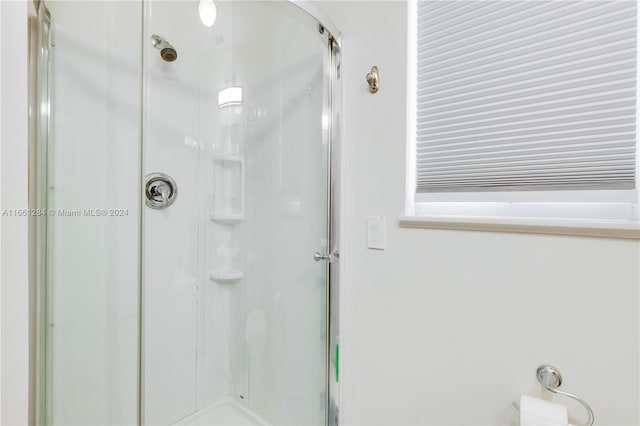 bathroom featuring a shower with shower door