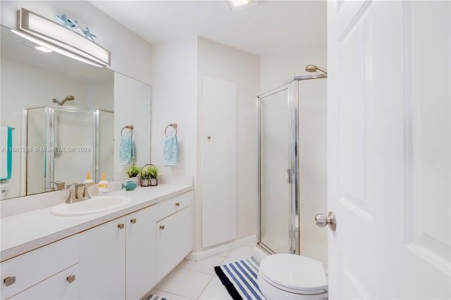 bathroom with tile patterned flooring, walk in shower, vanity, and toilet