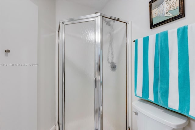 bathroom with an enclosed shower and toilet