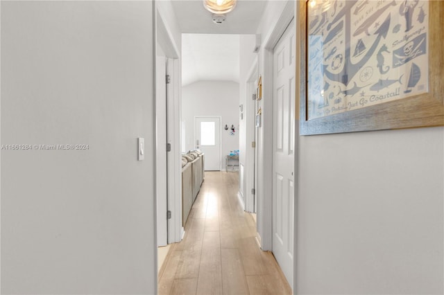 corridor featuring lofted ceiling and light hardwood / wood-style flooring