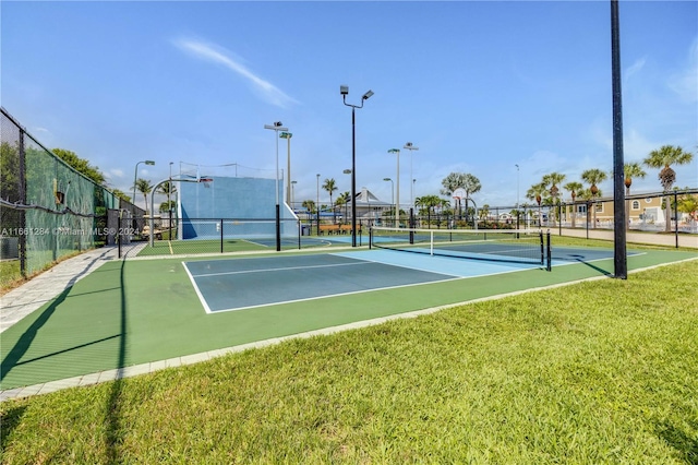 view of tennis court featuring a lawn