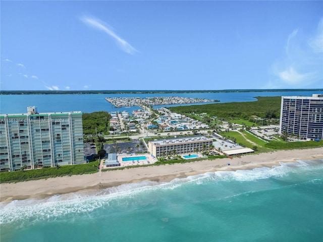 birds eye view of property featuring a water view and a beach view