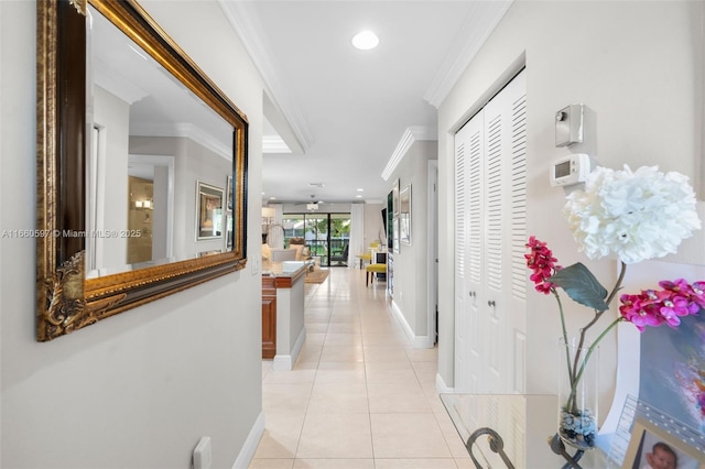 hall with light tile patterned floors and crown molding