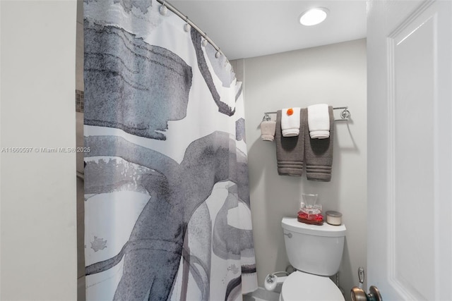 bathroom featuring curtained shower and toilet