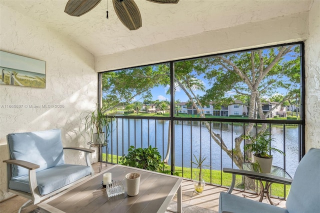 sunroom featuring a water view and ceiling fan