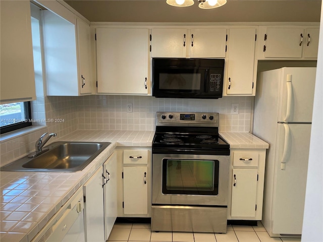 kitchen with tile counters, sink, light tile patterned flooring, stainless steel range with electric cooktop, and white fridge