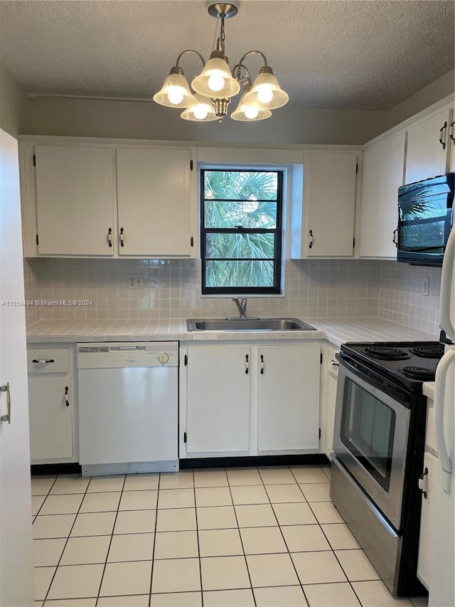 kitchen featuring sink, hanging light fixtures, white cabinetry, stainless steel appliances, and decorative backsplash