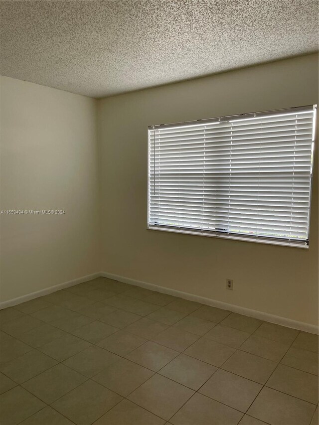 9235 SW 8th St Unit 406, Boca Raton, FL 33428 - spare room with a textured ceiling and baseboards