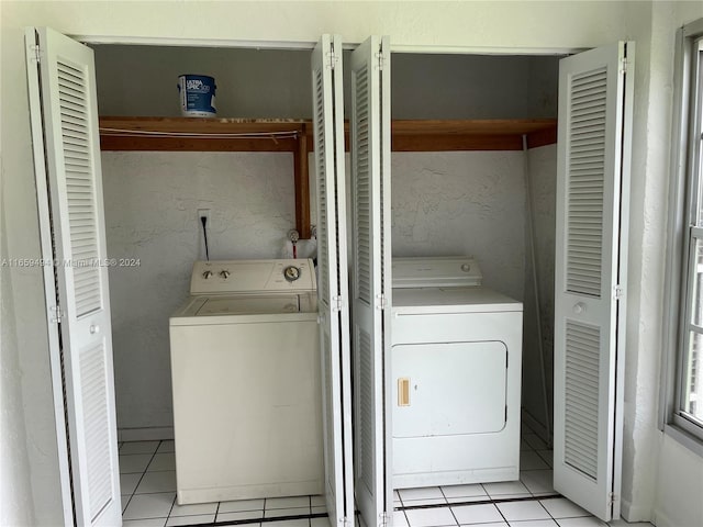 laundry room featuring light tile patterned flooring and washer and clothes dryer