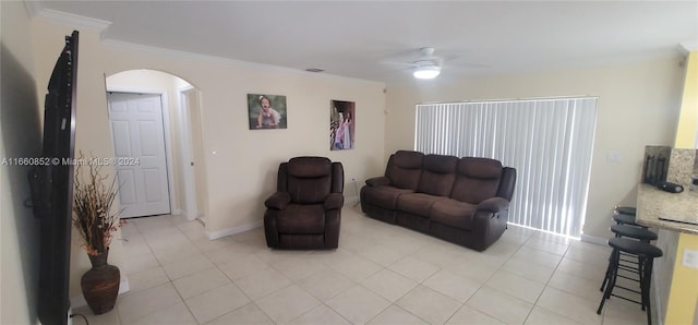 living room with ceiling fan, crown molding, and light tile patterned floors