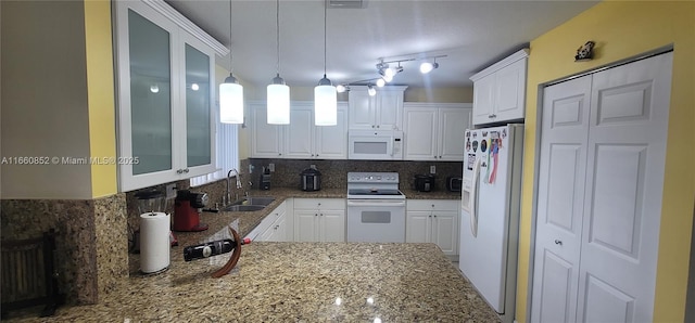 kitchen featuring tasteful backsplash, light stone counters, white appliances, white cabinetry, and a sink