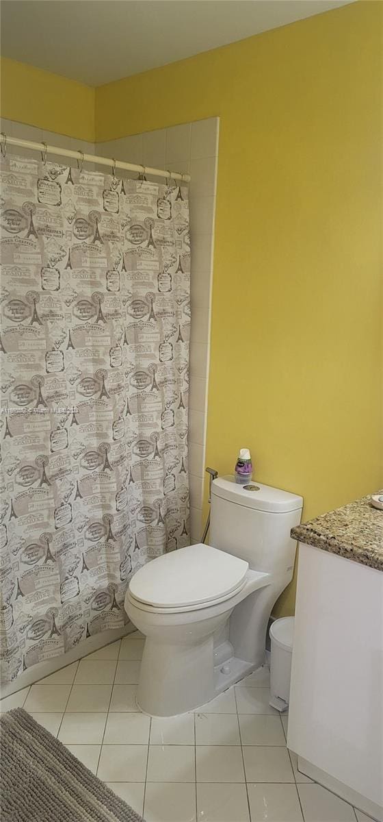 bathroom with vanity, toilet, a shower with shower curtain, and tile patterned floors